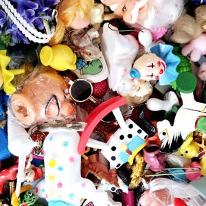 May include: A collection of colorful and whimsical toys, including a rocking horse, a doll, a rocking chair, and a variety of other small toys. The toys are made of plastic, wood, and fabric.