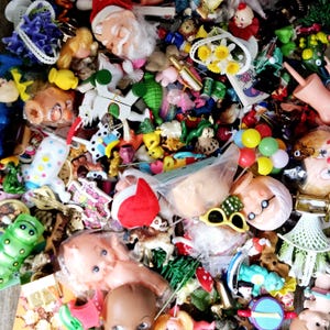 May include: A large collection of colorful plastic toys, including dolls, animals, and figures. There are also some small, decorative items, such as flowers and a bottle of wine.