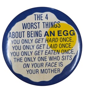 Peut inclure: Un bouton rond bleu avec le texte "THE 4 WORST THINGS ABOUT BEING AN EGG" et d'autres textes humoristiques. Le bouton a un design blanc en forme d'&oelig;uf avec un jaune d'&oelig;uf jaune.