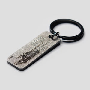 May include: A silver metal keychain with a black metal ring. The keychain features a black and white image of a tank with the text "GERMAN WWII TIGER TANK 1942-1945 T-12".