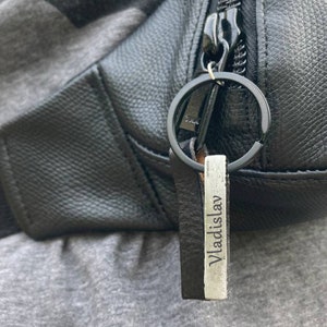 May include: A black leather fanny pack with a silver keychain that says "Vladislav".