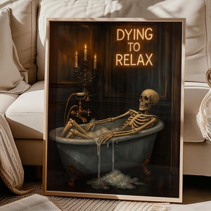 May include: Framed art print featuring a skeleton relaxing in a bathtub filled with bubbles. The artwork has a vintage aesthetic with a dark color palette. The text "DYING TO RELAX" is displayed in neon-style lettering above the tub.