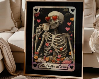 May include: A framed art print featuring a skeleton wearing heart-shaped sunglasses and drinking from a coffee cup. The skeleton is surrounded by flowers and hearts, with the text "The Coffee Lover" at the bottom. The print has a black background.