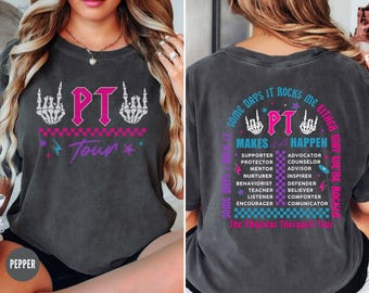 Puede incluir: Una camiseta gris oscuro con un diseño gráfico rosa y azul. El gráfico presenta una calavera y huesos cruzados con las letras "PT" en el centro. El texto "Some days it rocks me either way we're rockin'" está impreso en la parte posterior de la camiseta. El texto "PT Makes it all Happen" está impreso debajo del gráfico. El texto "The Physical Therapy Tour" está impreso en la parte inferior de la camiseta.