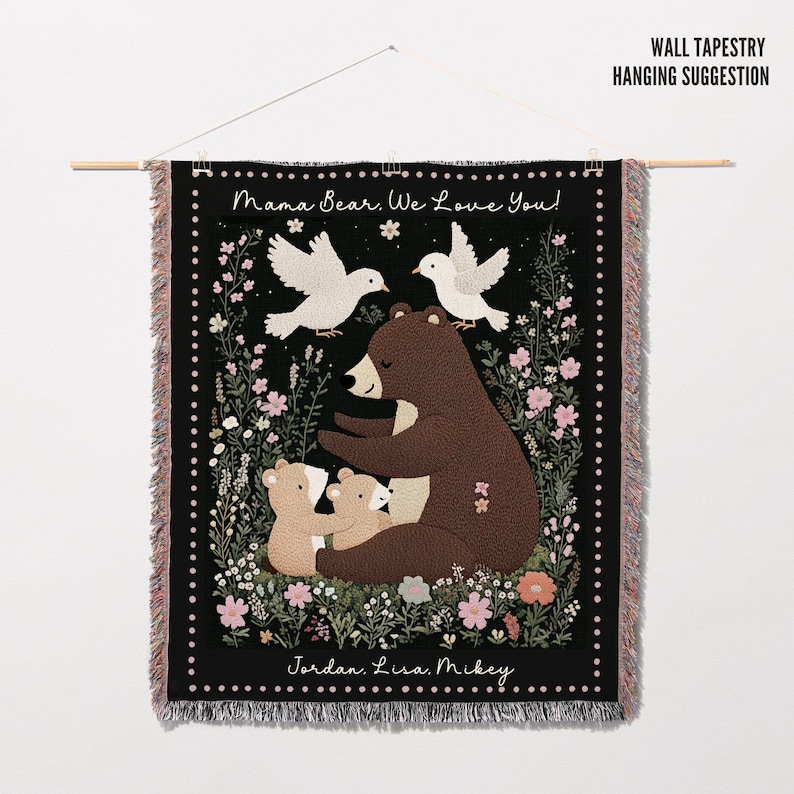 May include: Black tapestry featuring a mama bear and two cubs surrounded by flowers. The text "Mama Bear. We Love You!" is at the top and "Jordan. Lisa. Mikey" is at the bottom.