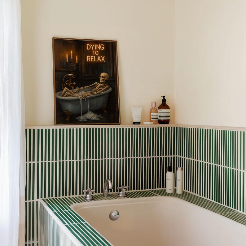 May include: A bathroom scene featuring a framed artwork with a skeleton relaxing in a bathtub, with the text "DYING TO RELAX". The bathroom has green and white striped tiles and a white bathtub. Several bottles of bath products are on a shelf.