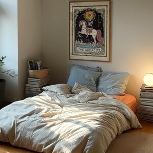 Puede incluir: Una funda n&oacute;rdica beige con una almohada azul claro en una cama con un p&oacute;ster enmarcado de un esqueleto montando un unicornio con el texto "The Audacity" sobre un fondo blanco.