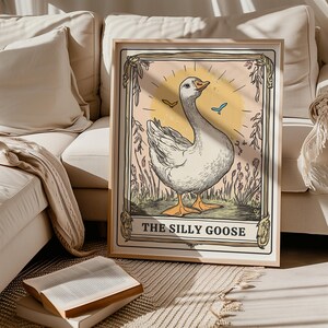 May include: A vintage-style illustration of a white goose with a pink background. The goose is surrounded by green foliage and flowers. The text "The Silly Goose" is printed below the goose.