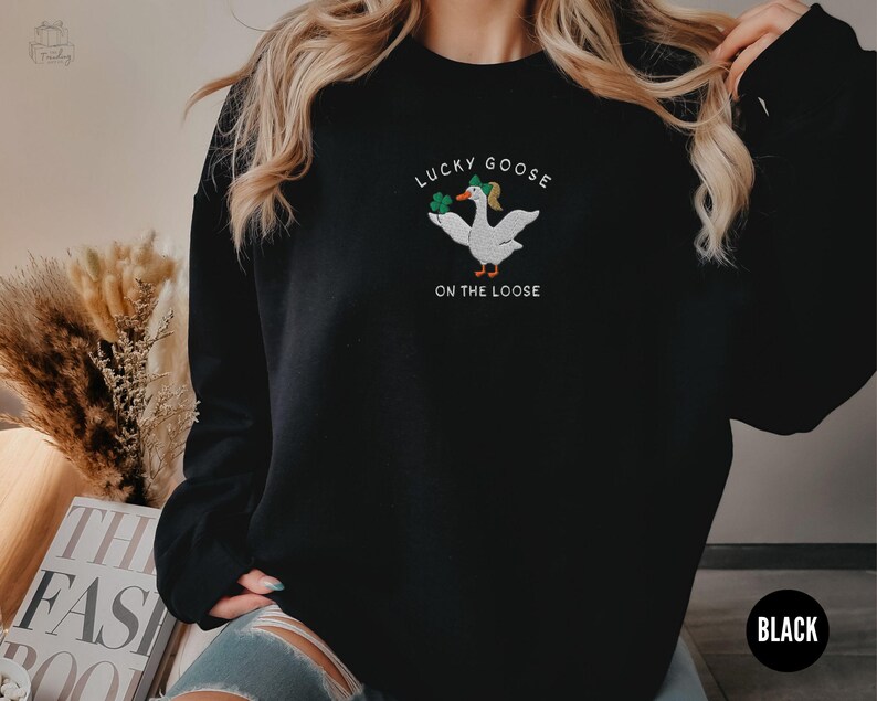 May include: Black sweatshirt with a white goose graphic and the text "Lucky Goose on the Loose".