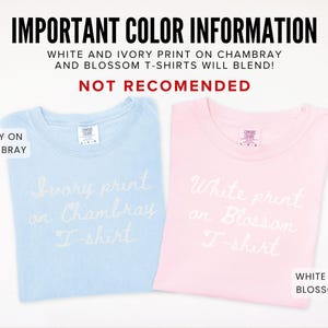 May include: Two t-shirts, one light blue and one pink, are displayed. The light blue shirt has "Ivory print on Chambray T-shirt" in white script. The pink shirt has "White print on Blossom T-shirt" in white script. Text at the top reads "IMPORTANT COLOR INFORMATION".