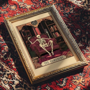 May include: Framed artwork featuring a skeleton lounging in a burgundy armchair, holding a wine glass. The artwork is set in a room with bookshelves and a patterned rug. The text "THE HOMEBODY" is at the bottom.