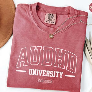 May include: Crimson red t-shirt with white text that reads "ADHD University - Honours Program".