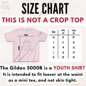 Op de afbeelding: Een roze jeugd-T-shirt met een maattabel. De tabel toont breedte- en lengtematen in inches voor de maten XS tot XL. Tekst op de afbeelding luidt: "THIS IS NOT A CROP TOP" en "The Gildan 5000B is a YOUTH SHIRT."