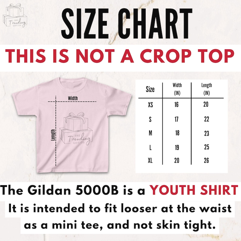 Op de afbeelding: Een roze jeugd-T-shirt met een maattabel. De tabel toont breedte- en lengtematen in inches voor de maten XS tot XL. Tekst op de afbeelding luidt: "THIS IS NOT A CROP TOP" en "The Gildan 5000B is a YOUTH SHIRT."
