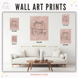 May include: A set of five wall art prints featuring a pink background with a black line drawing of stacked gift boxes. The text "THE TRENDING GIFT CO." is on the largest print. The prints are available in five sizes: 9x11 inches, 11x14 inches, 16x20 inches, 18x24 inches, and 30x40 inches.