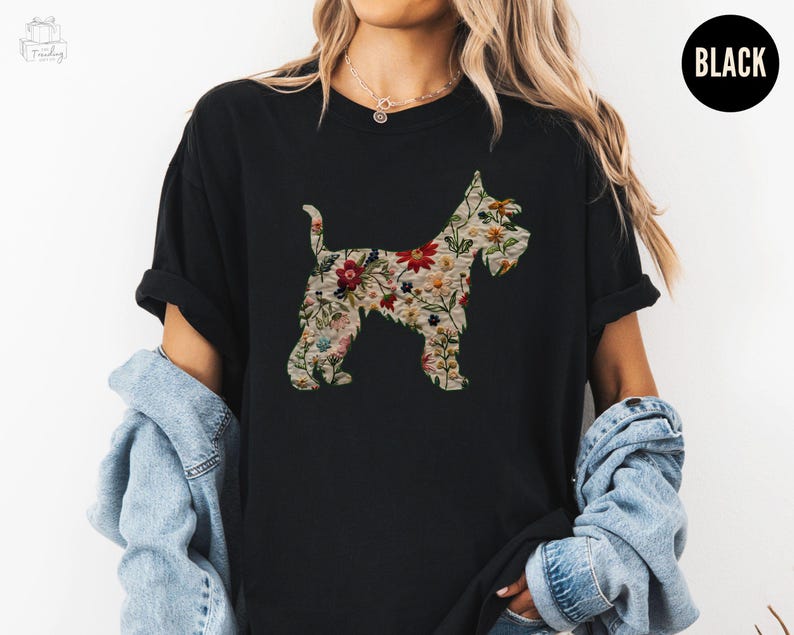 Puede incluir: Una camiseta negra con una silueta floral de un perro. El perro est&aacute; delineado con un patr&oacute;n floral de varios colores, incluyendo rosa, rojo, amarillo y verde.