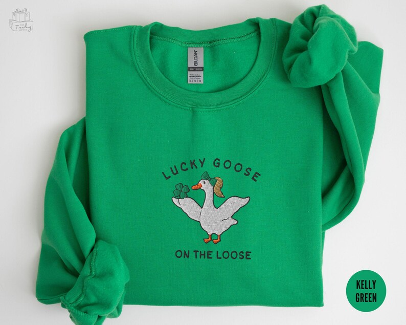 May include: A kelly green sweatshirt with a white embroidered goose wearing a shamrock hat and the text "Lucky Goose on the Loose".