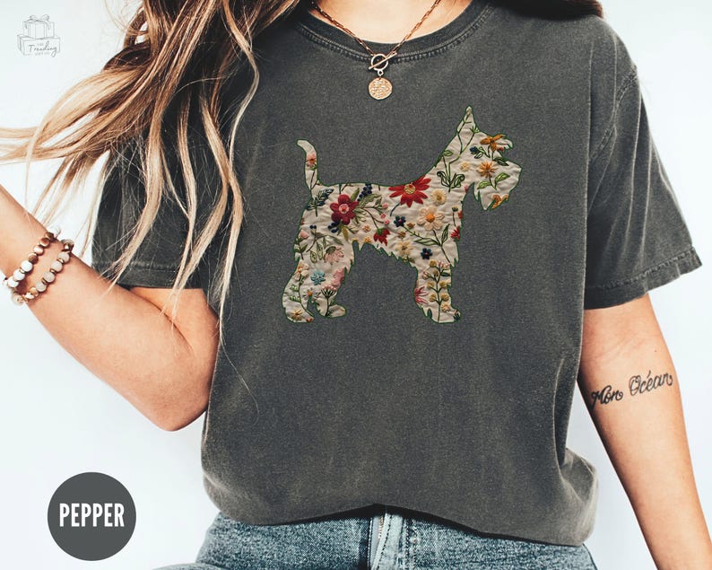 Puede incluir: Una camiseta gris oscuro con un estampado floral de una silueta de perro. El texto "Pepper" es visible en la parte inferior de la imagen.
