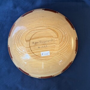 K&ouml;nnte beinhalten: Eine Holzschale mit einem braunen und roten Einlegemuster. Die Schale ist signiert mit "Tom Raymond #1464" und kostet 175 &euro;.
