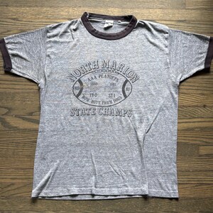 Camiseta vintage dos anos 1970/80 do time de futebol americano campeão da North Marion State, modelo Varsity Collegiate Ringer, EUA.