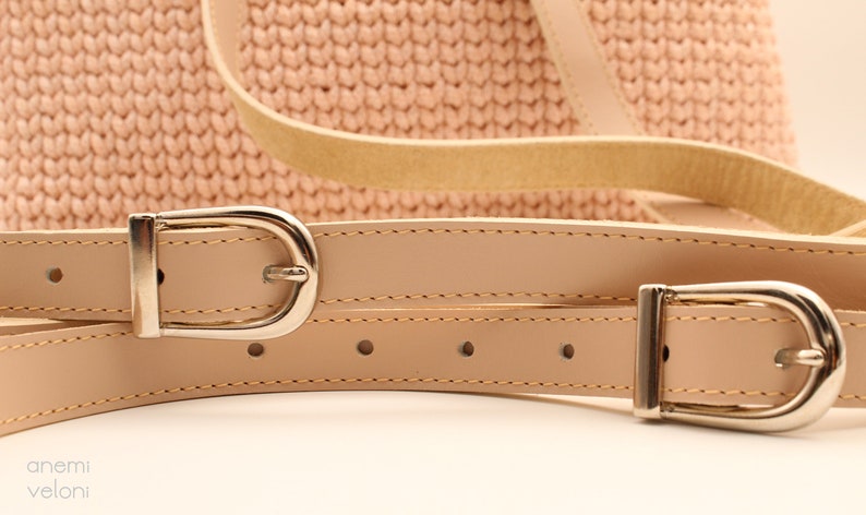 Puede incluir: Dos correas de cuero beige con hebillas plateadas. Las correas est&aacute;n cosidas y tienen un brillo sutil.