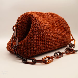 May include: A brown crocheted handbag with a thick, brown chain strap.
