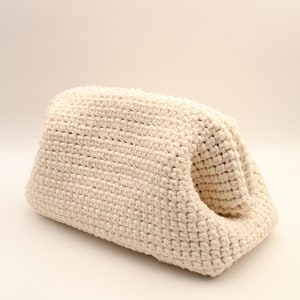 Pu&ograve; includere: Una borsa in crochet color crema con un design unico a apertura superiore. La borsa &egrave; realizzata in filato spesso e testurizzato e ha un aspetto morbido e naturale.