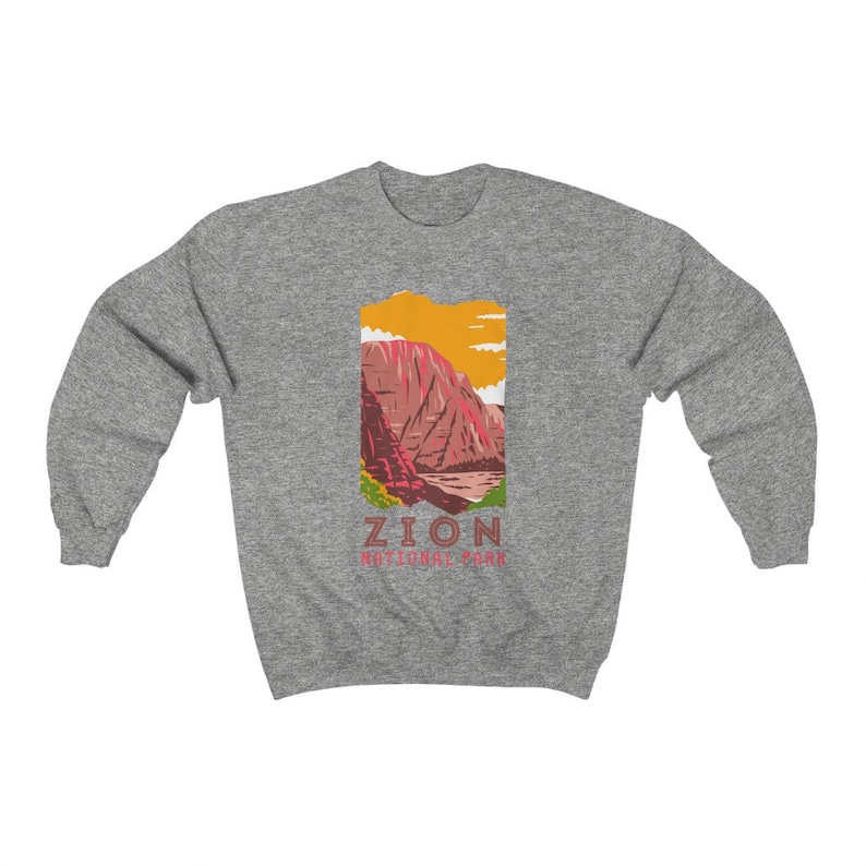 May include: A gray sweatshirt with a graphic of a mountain range in Zion National Park. The graphic is in a vintage style with a yellow, orange, red, and green color scheme. The text "Zion National Park" is printed below the graphic.