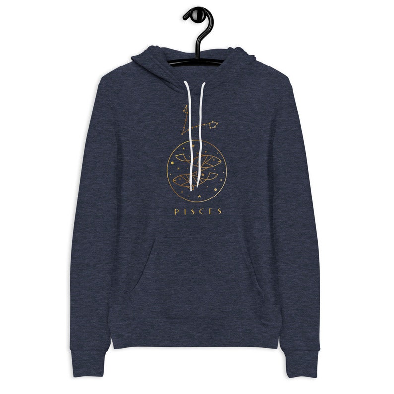 May include: A navy blue hoodie with a gold Pisces zodiac sign and constellation design. The text "PISCES" is printed below the design.