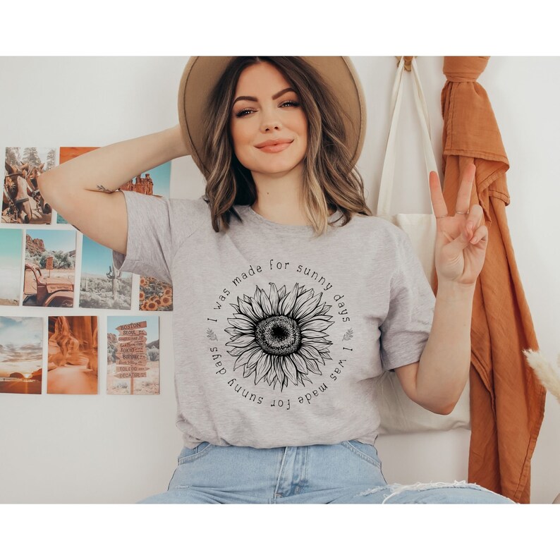 May include: A gray t-shirt with a black and white sunflower graphic and the text "I was made for sunny days".