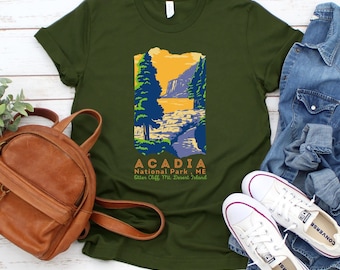 Könnte beinhalten: Ein grünes T-Shirt mit einer Vintage-Illustration einer Landschaftsszene aus dem Acadia National Park in Maine. Der Text "Acadia National Park, ME Otter Cliffs, Mt. Desert Island" ist unter dem Bild gedruckt.
