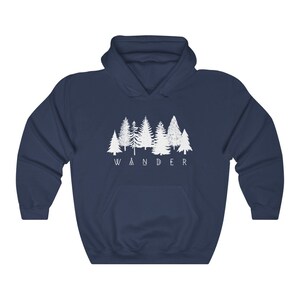 May include: A navy blue hooded sweatshirt with a white graphic of a row of trees and the word "WANDER" underneath.