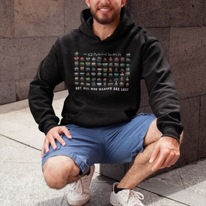 May include: A person wearing a black hoodie with a graphic of the 62 National Parks of the United States. The graphic is in color and includes the text "The 62 National Parks of the US" and "Not all who wander are lost".