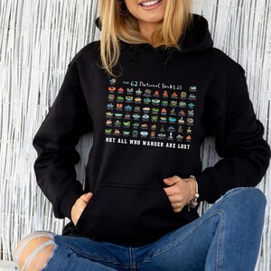 May include: A black hoodie with a graphic of the 62 National Parks in the United States. The graphic is a colorful illustration of each park's unique features. The text "The 62 National Parks" and "Not all who wander are lost" is printed on the hoodie.