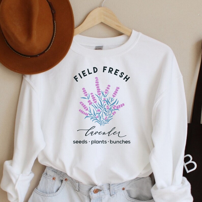 May include: White sweatshirt with the text "FIELD FRESH lavender seeds. plants. bunches" and a graphic of purple lavender flowers.