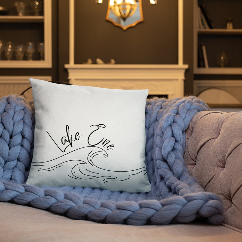 May include: White throw pillow with black text that reads "Lake Erie" and a stylized wave design.
