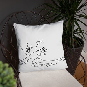 May include: White pillow with black text and a wave design. The text reads "Lake Erie".