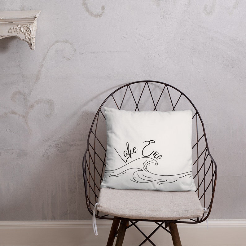 May include: White throw pillow with black cursive text that reads "Lake Erie" and a simple line drawing of waves.