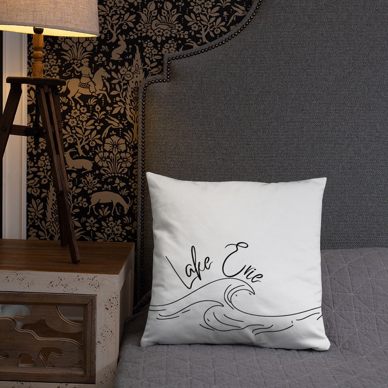 May include: White pillow with black text that says "Lake Erie" and a stylized wave design.