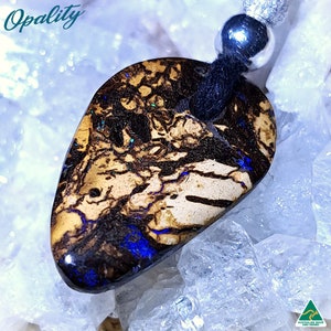 May include: A dark brown and blue opal pendant with a black cord and silver bead. The opal has a unique pattern of black veins and blue flashes.