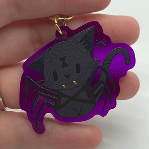 Simpatico portachiavi Spoopy Spooder Spider Cat - acrilico colorato su entrambi i lati viola - attaccamento stella - denti di mais caramelle cosplay di Halloween raccapriccianti
