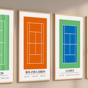 May include: Four framed vertical wall art prints depicting tennis court diagrams. The first is green for Wimbledon, the second orange for Roland Garros, the third blue on green for US Open, and the fourth blue for Australian Open, each with text.