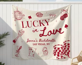 May include: A cream-colored banner with red illustrations and text that reads "LUCKY in Love" with "Jenna's Bachelorette Las Vegas, NV" below. The banner features casino-themed graphics like dice, playing cards, and poker chips.