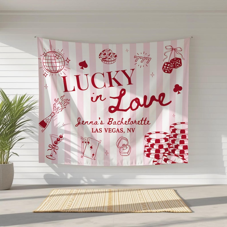 May include: A pink and white striped banner with red illustrations of casino-themed items, including dice, playing cards, and poker chips. The banner reads "Lucky in Love" and "Jenna's Bachelorette Las Vegas, NV."