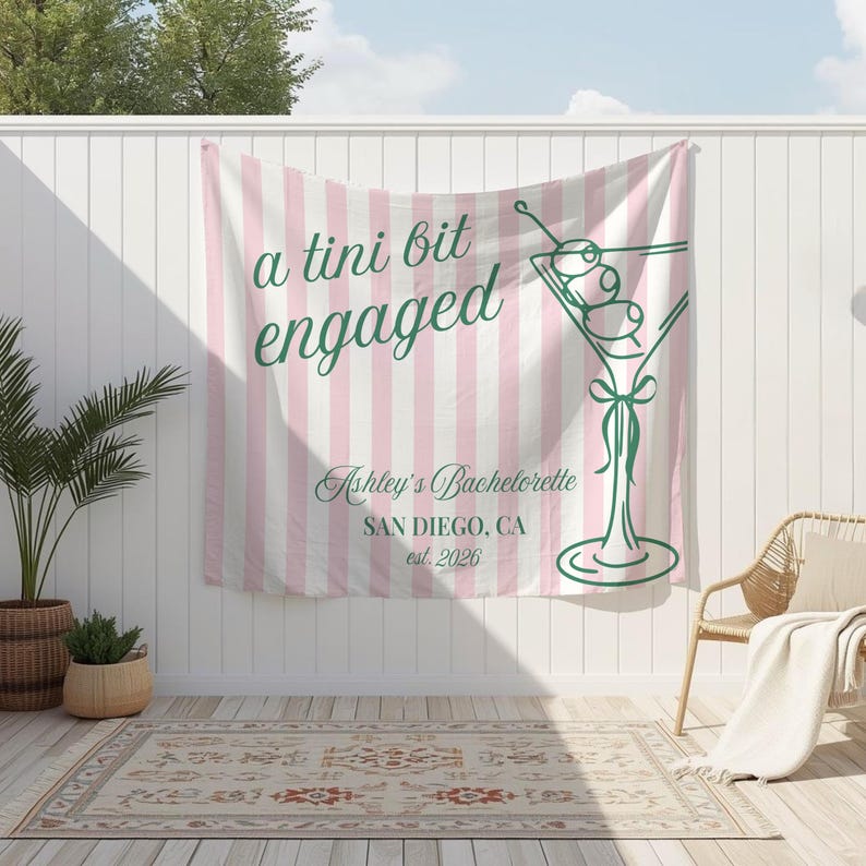 K&ouml;nnte beinhalten: Ein rosa-wei&szlig; gestreifter Banner mit dem Text "a tini bit engaged" und einer gr&uuml;nen Martini-Glas-Illustration. Das Banner enth&auml;lt auch "Ashley's Bachelorette" und "SAN DIEGO, CA est. 2026".