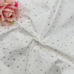 Popeline di cotone premium con stelle argentate natalizie. Stelle argentate su fondo bianco. Larghezza 240 cm.