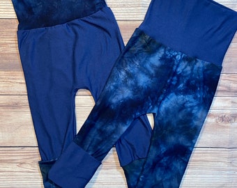 Puede incluir: Dos pares de leggings azules con un patrón de tie-dye. Un par es azul sólido con una cintura de tie-dye. El otro par tiene un patrón de tie-dye en todo.