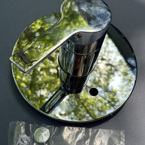May include: Chrome shower head diverter valve with a round base and a lever handle. The valve is designed to switch between a shower head and a handheld shower head.
