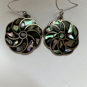 May include: A pair of silver earrings with a black background and iridescent abalone shell inlay in a floral design.