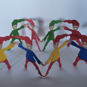 May include: A heart-shaped arrangement of paper figures in various colors, including red, green, yellow, and blue. Each figure has a smiling face, holding hands with the adjacent figures. The figures have long, flowing hair and are set against a white background.